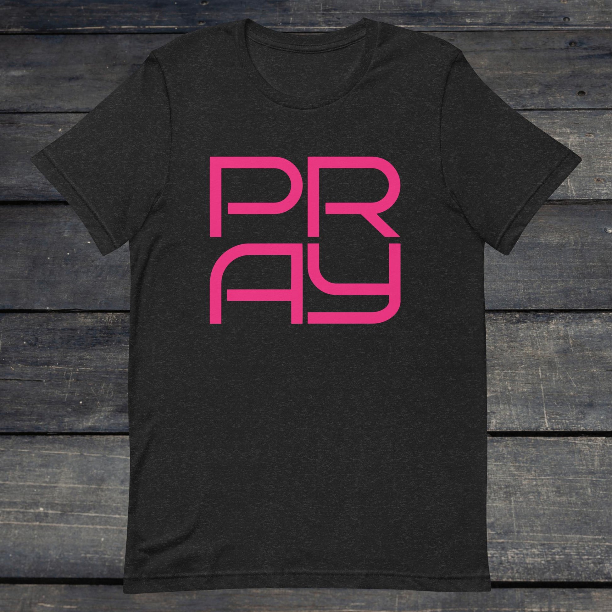 A photo of the Pray 4 Tee. This tee is heather grey with pink text that reads P-R-A-Y in large stylish lettering.