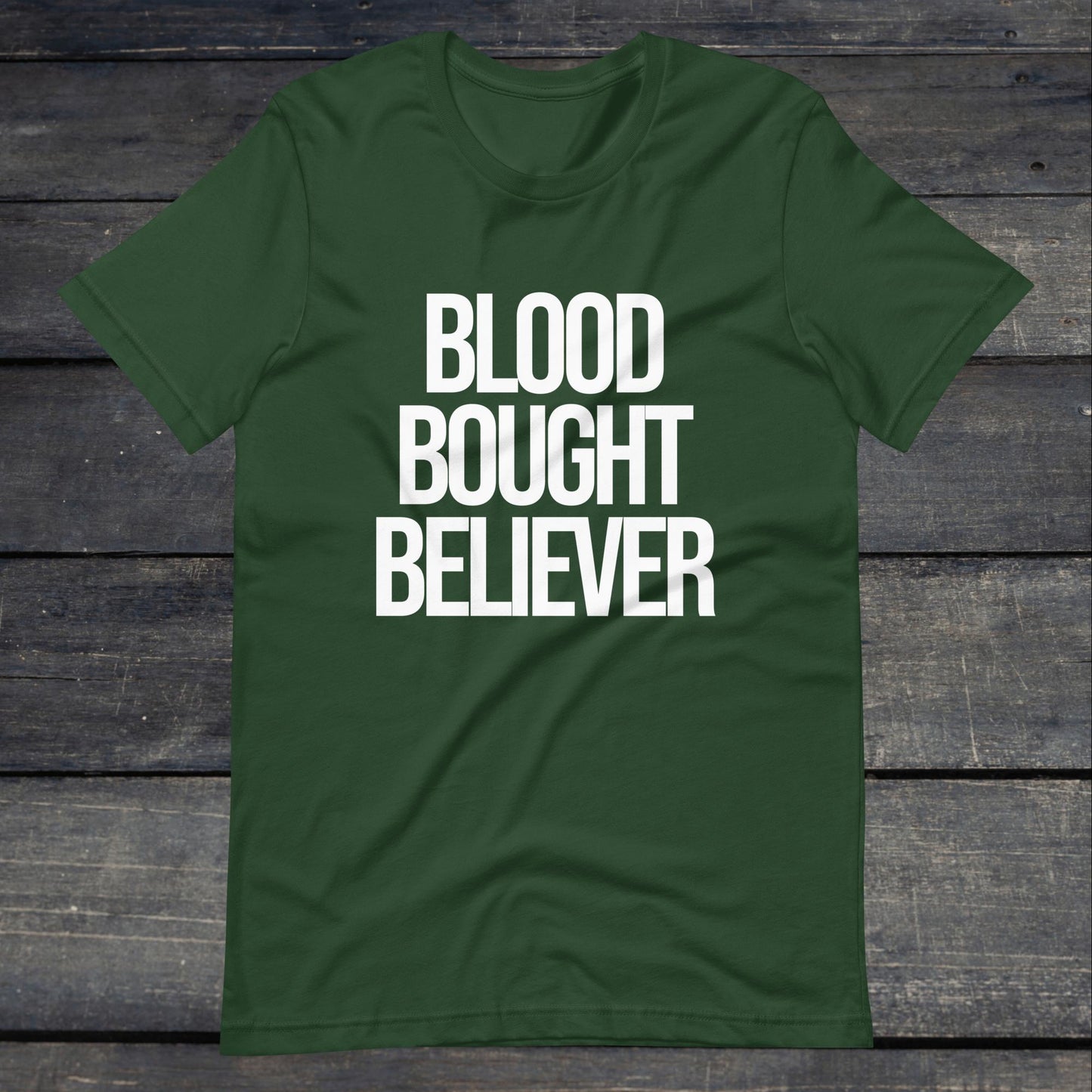 A photo of the Blood Bought Believer Tee. This tee is forest green with white text that reads Blood Bought Believer in large bold lettering.