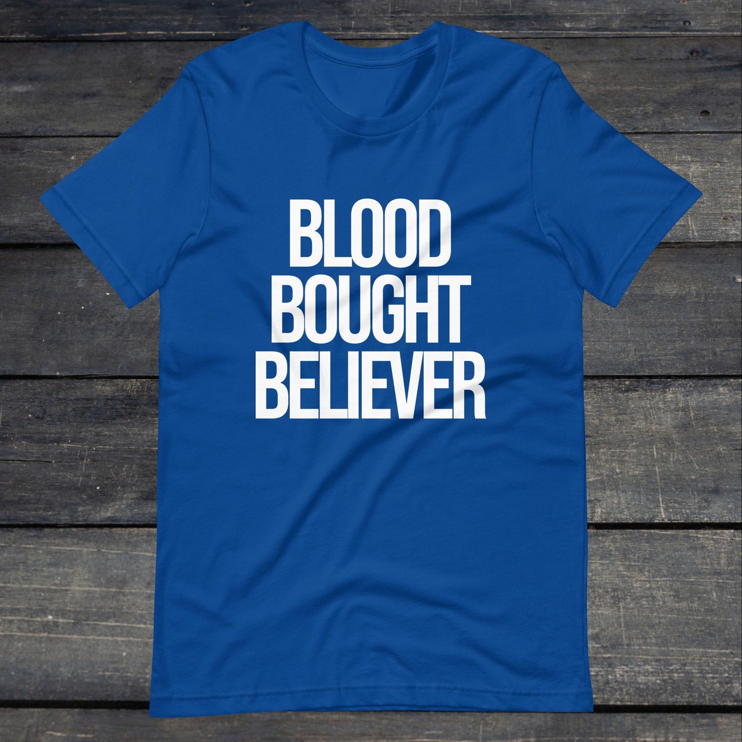 A photo of the Blood Bought Believer Tee. This tee is royal blue with white text that reads Blood Bought Believer in large bold lettering.